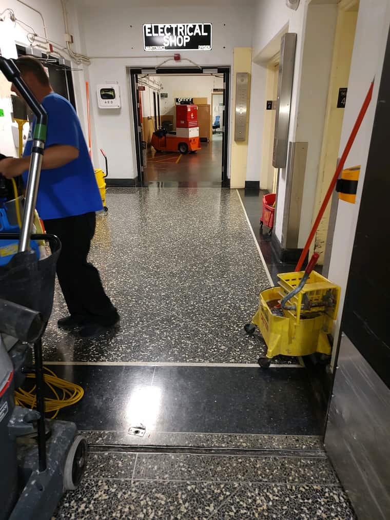 JSD team member cleaning a facility corridor